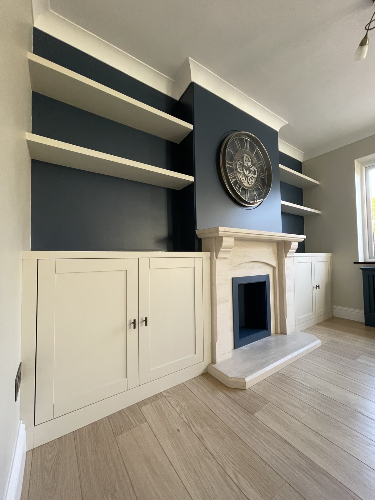 Bespoke media wall with floating shelves and fireplace
