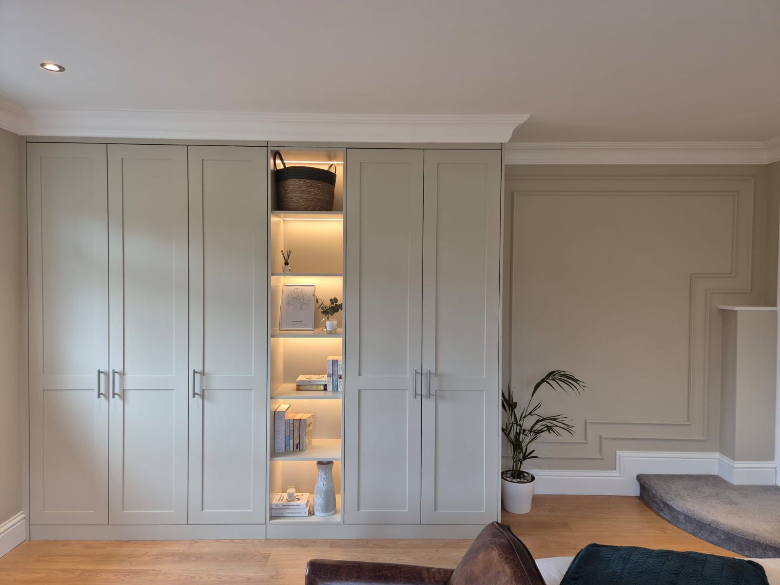 Fitted wardrobe with LED display shelves and wall panelling